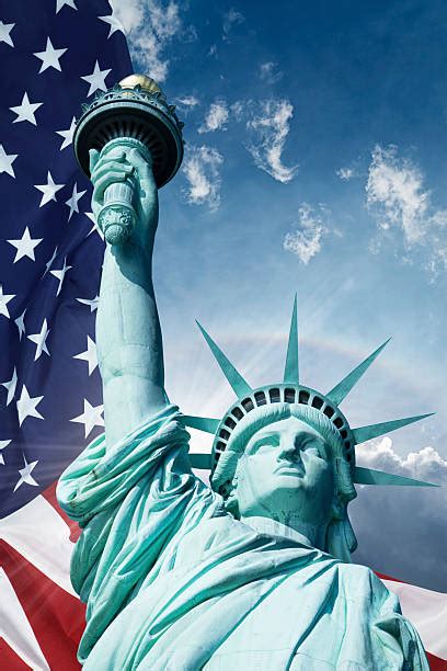 The Statue Of Liberty And The American Flag Stock Photos Pictures