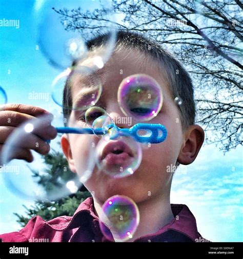Image Of Young Boy Blowing Bubbles With A Bubble Wand Stock Photo Alamy