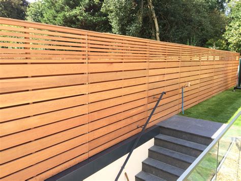 Cedar slatted fencing with a combination of large and smaller slats