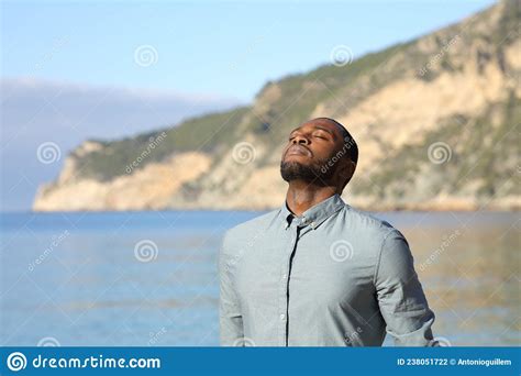 Casual Man With Black Skin Breathing Fresh Air On The Beach Stock Photo