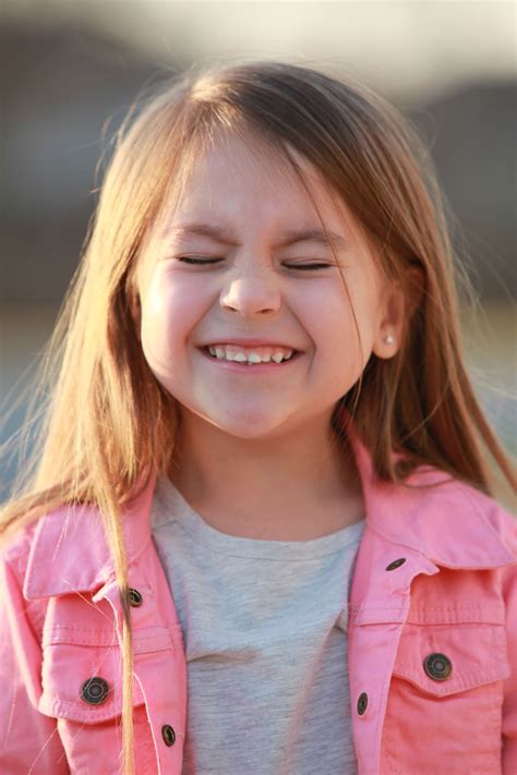 Cute Brown Haired Little Girl Closes Her Eyes And Wrinkles Up Her Nose
