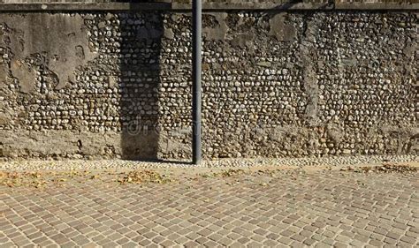 Old Wall With Peeled Plaster And Exposed Bricks Porphyry Sidewalk And