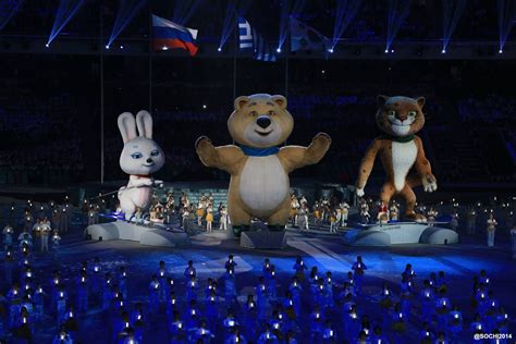 Two Teddy Bears And One Bunny Stand On Stage In Front Of An Audience At