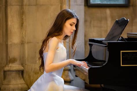 Portrait Of A Beautiful Girl Wearing White Wedding Dress At The Piano