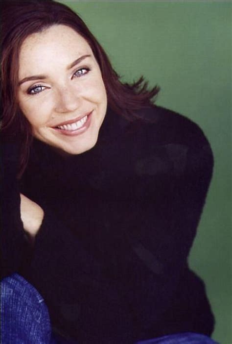 A Woman Smiling And Wearing A Black Sweater