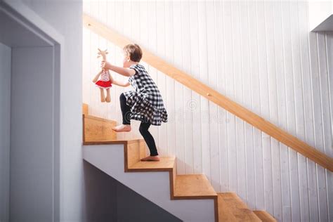 A Small Child With A Soft Toy Walking Up The Stairs Stock Image