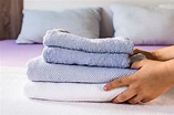 Free Photo | Close-up person putting towels on bed