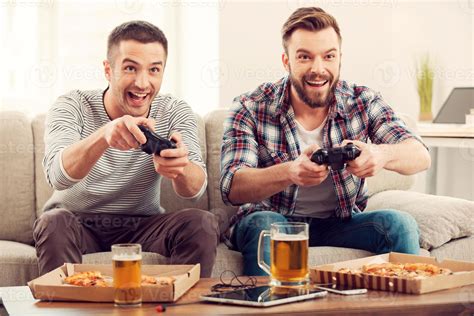 The Avid Gamers Two Young Happy Men Playing Video Games While Sitting