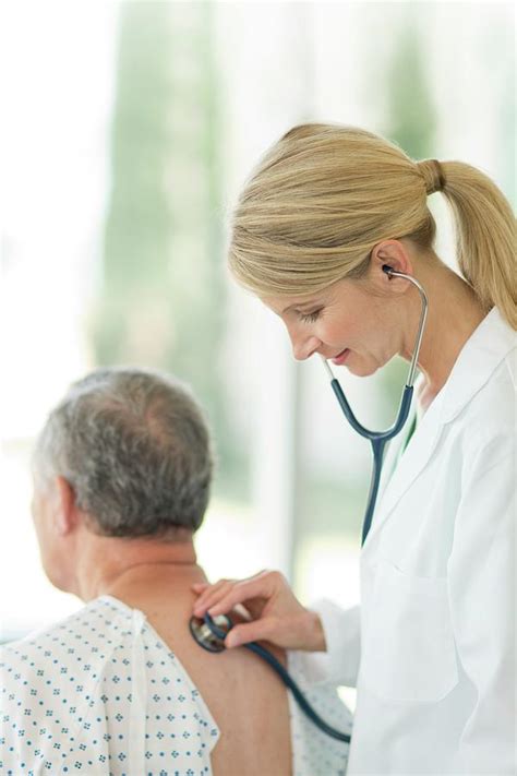 Female Doctor Using Stethoscope On Male Patient Photograph By Science