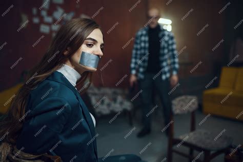 Premium Photo Maniac Kidnapper And Female Victim With Taped Mouth