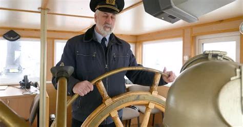 Portrait Captain Of Ship Holding Steering Wheel On Captain Bridge