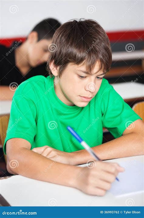 Teenage Schoolboy Writing At Desk During Stock Photo Image Of Class