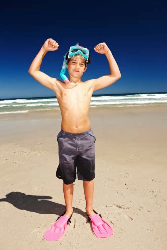 Boy Flexing His Muscles While Wearing Snorkeling Gear Stock Photo