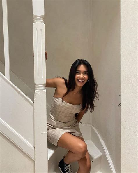 A Woman Is Sitting On The Stairs Posing For A Photo