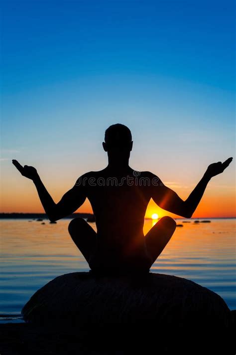 Meditating Man Silhouette On Vibrant Sunset Background Stock Image