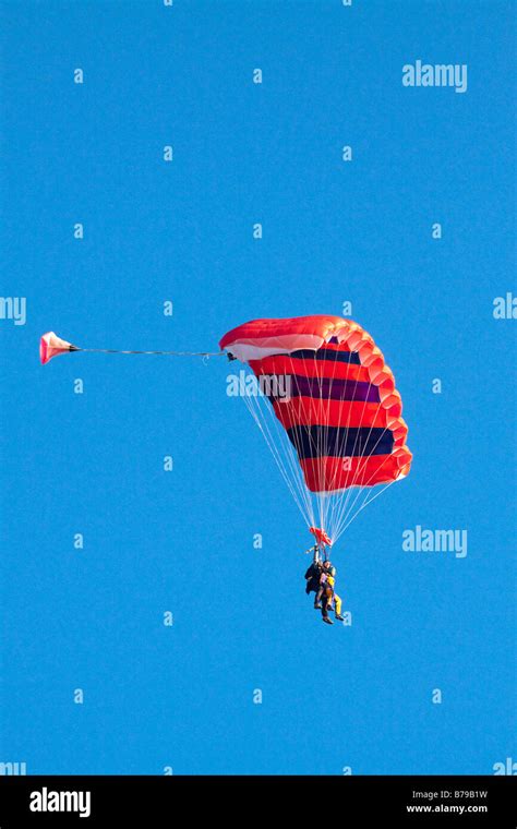 Red Striped Parachute Carrying Two People Glides The Blue Sky Hi Res