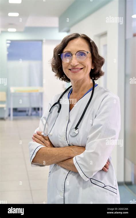 Vertical Portrait Of Female Happy Doctor Nurse Standing In Clinic