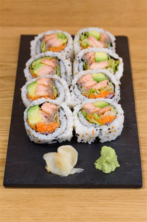 Salmon Avocado And Carrot Sushi Roll Served On A Slate Plate With
