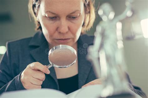 Attorney Woman Using Magnifying Glass For Law Book Reading Stock Photo
