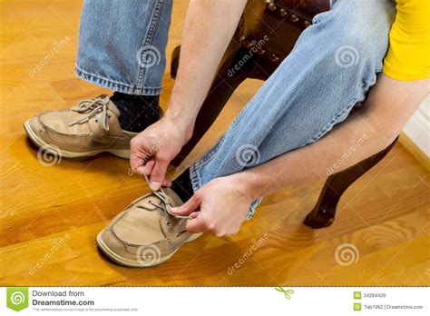 Man Putting On Shoes While Sitting On Footstool Royalty