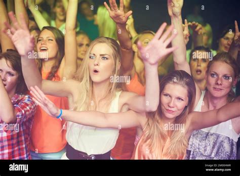 women hands up and dancing at music festival live band performance and techno rave party in