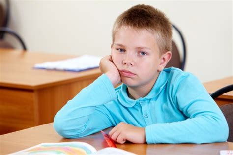 Bored Little Boy At His Desk Photo Free Download