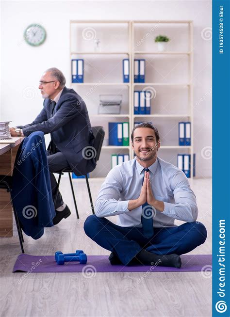 Two Employees Doing Physical Exercises At Workplace Stock Photo Image