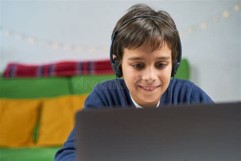 Concentrated Boy Using Laptop Wearing Headphones Sitting Alone At