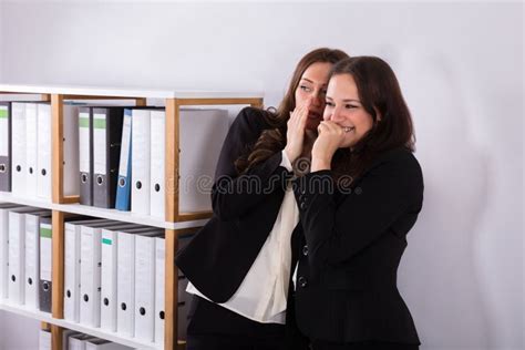 Businesswoman Whispering In Colleagues Ear Stock Image Image Of