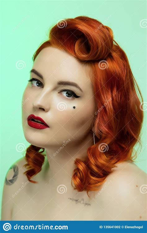 Portrait Of A Beautiful Red Hair Girl With Pin Up Make Up And Hair