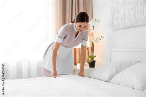 Young Maid Making Bed In Light Hotel Room Stock 写真 Adobe Stock