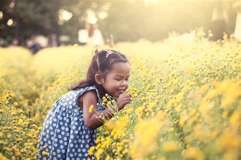 Premium Photo Child Asian Little Girl Smelling Flower In The Garden