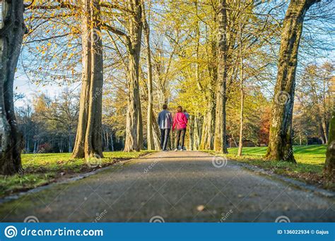 Young Couple With A Baby Walking Through An Autumn Park Stock Photo