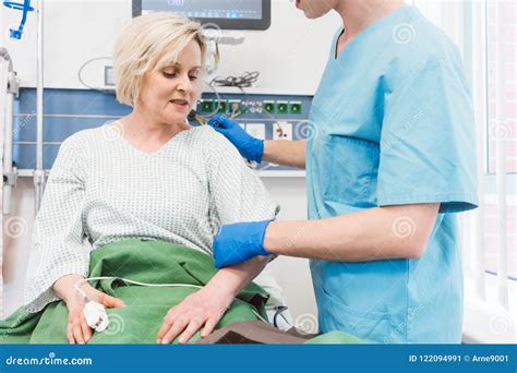 Nurse Caring For Patient In Recovery Room Of Hospital Stock Image