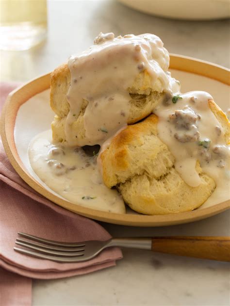 Two Biscuits Covered In Gravy On A Plate