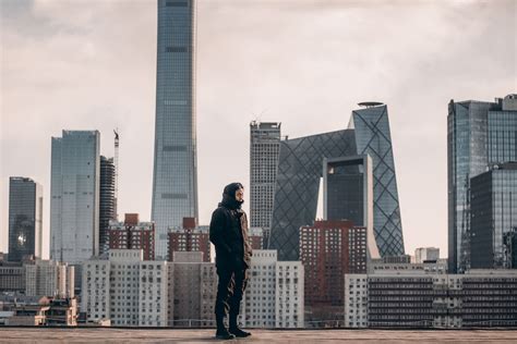 Man Standing In Front Of Tall Buildings Photo Free People Image On