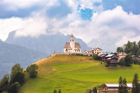 Panoramic View Of Mountain Village With A Church In Dolomite Alps Stock