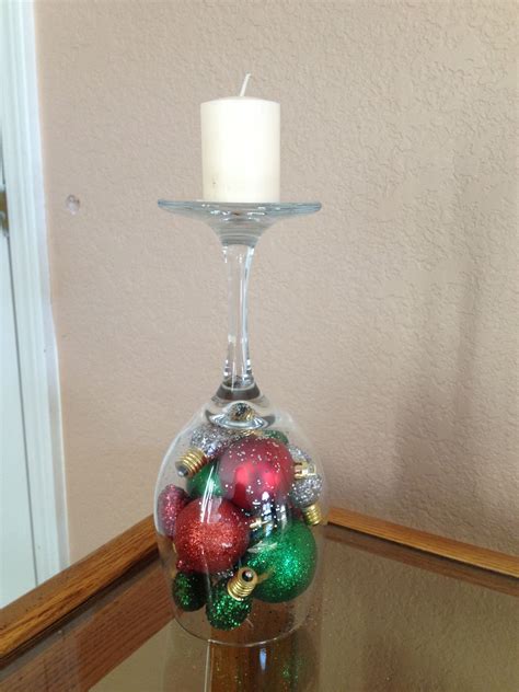 A Wine Glass Filled With Christmas Ornaments On Top Of A Table Next To