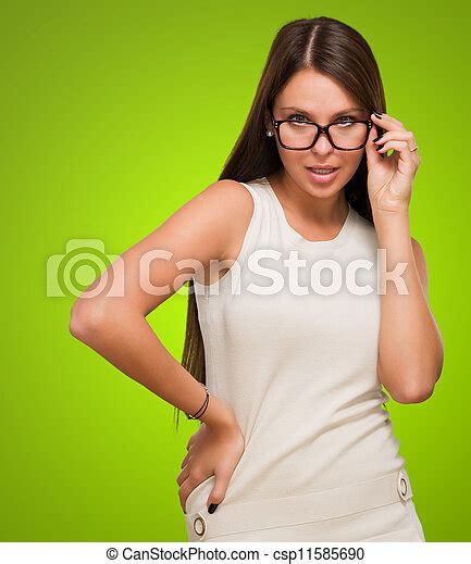 sexy woman with glasses posing against a green background canstock