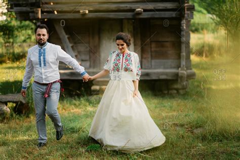 Romanian Bride And Groom Walk Hand In Hand At Country Wedding Stock