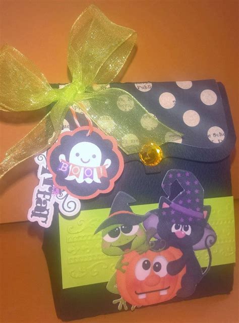 A Halloween Treat Bag With An Orange And Purple Pumpkin On It Tied To