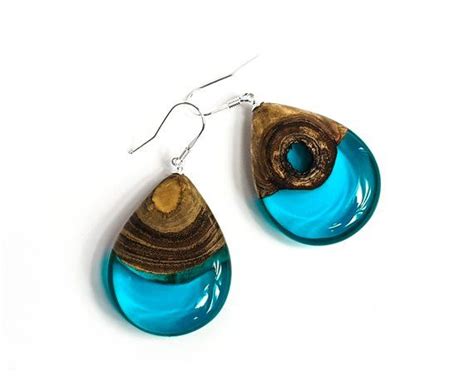 A Pair Of Earrings With Blue Glass And Wood In The Shape Of Tears On A
