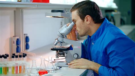 Male scientist doing microscope research. Man scientist looking ...
