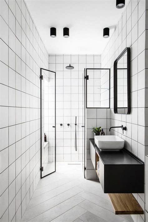 A White Tiled Bathroom With Black Counter Tops