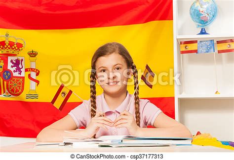 Cute Schoolgirl Learning Spanish At The Classroom Cute Schoolgirl With Plaits Holding Two