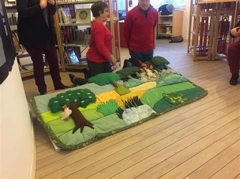 Several People Standing Around In A Room With Bookshelves And Stuffed