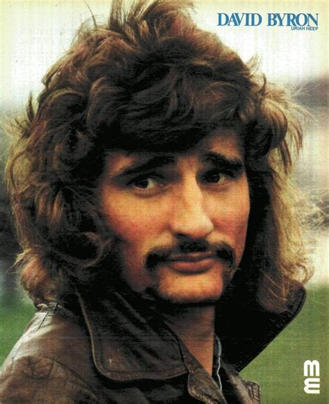 A Man With Long Hair And A Moustache On His Face Is Looking At The Camera