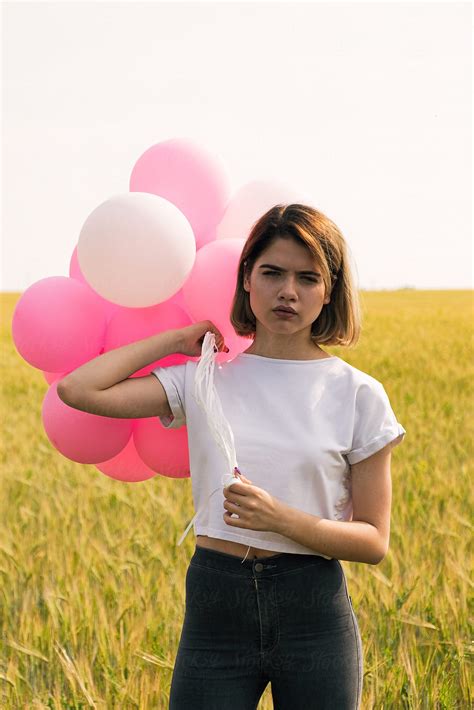 serious teen girl with balloons looking at camera by stocksy contributor danil nevsky stocksy