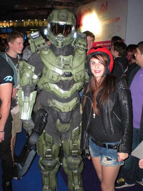 A Woman Standing Next To A Man In A Halo Armor Suit At An Event With
