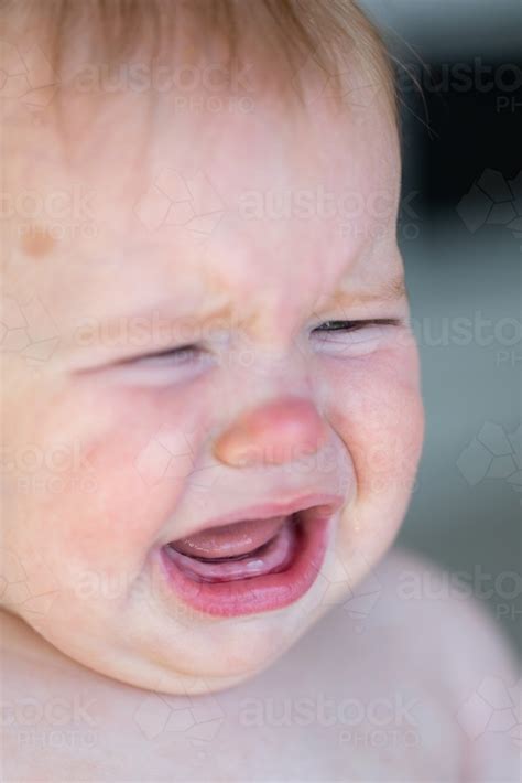 Image Of Baby With New First Tooth Looking Sad Crying Austockphoto